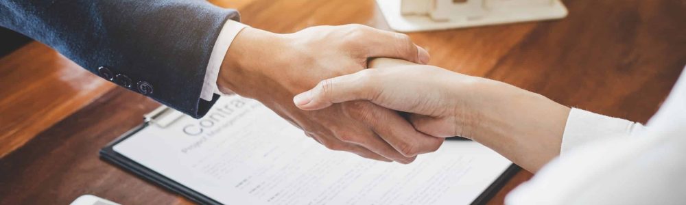 Real estate agent and customers shaking hands together celebrating finished contract after about home insurance and investment loan, handshake and successful deal.